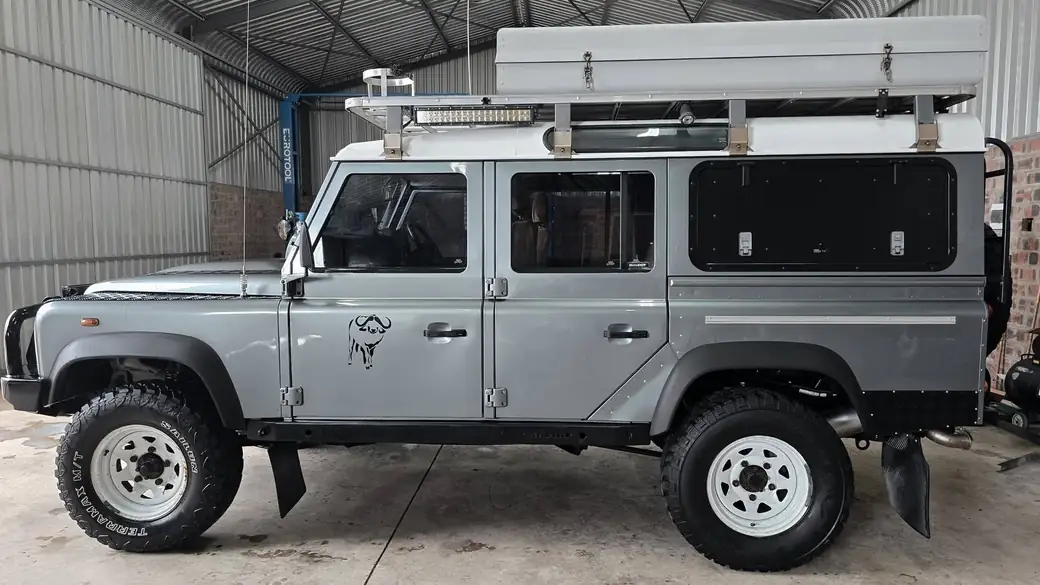 Grey Land Rover Defender 110 with a pop-top roof conversion in the Anti-Rust workshop