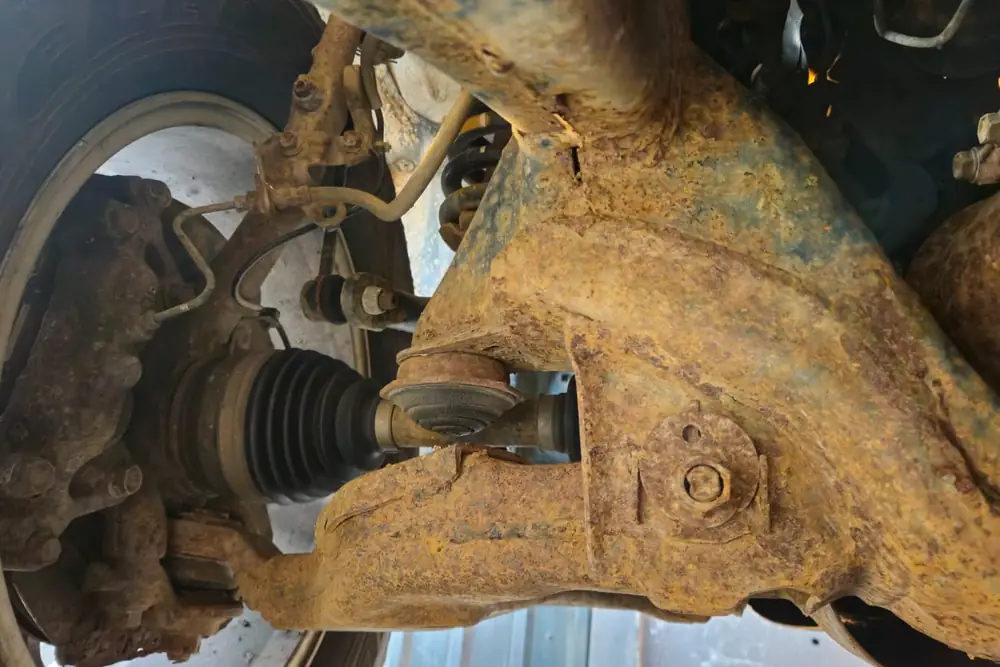 Front suspension before treatment — heavy surface corrosion across the steel